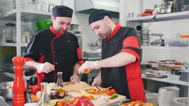Dois homens chefs trabalhando em servir prato de peixe na tábua de corte
 - Filmagem, Vídeo