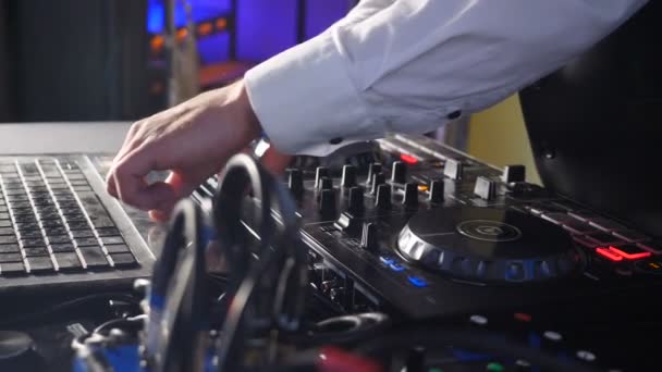 DJ achter console, op het podium, het mixen van tracks in atmosferische Dance Party strobing en knipperende lichten. Close-up van DJ-handen die muziek spelen. Close-up van DJ mixer controller Desk in Night Club Disco Party - Video