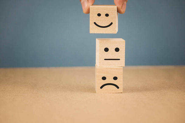 wooden cubes with smiling emoticons and sad one. - Photo, Image