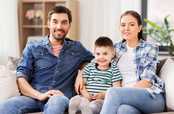 portrait of happy family sitting on sofa at home - Foto, imagen