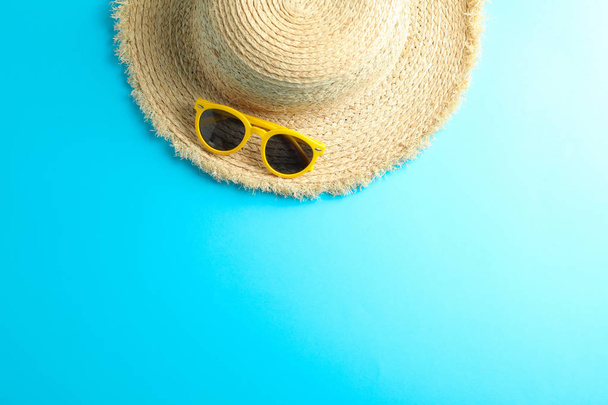 Strohhut und Sonnenbrille auf farbigem Hintergrund, Platz für Text - Foto, Bild