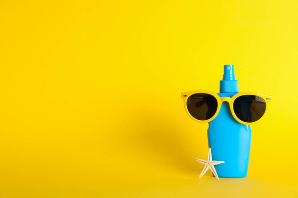 Sunscreen spray with starfish and sunglasses on color background - Fotoğraf, Görsel