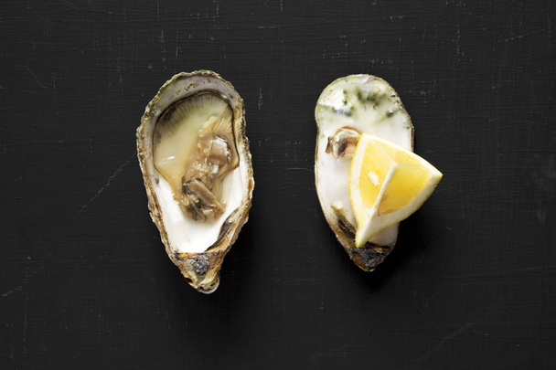 Top view, fresh oyster with slice of lemon on a black background - Photo, Image