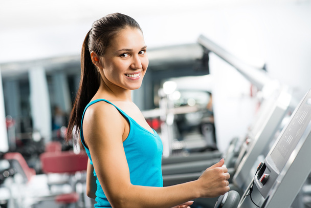 attractive young woman runs on a treadmill - Photo, Image