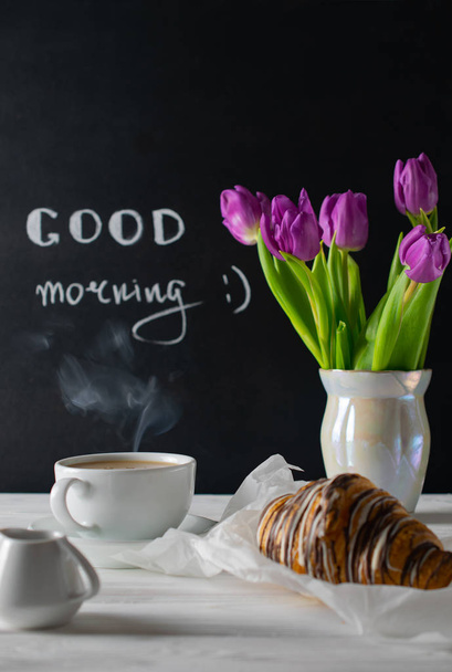 Ambiente de pequeno-almoço positivo e feliz com tulipas bouquest, café e croissant. Bom dia.
 - Foto, Imagem
