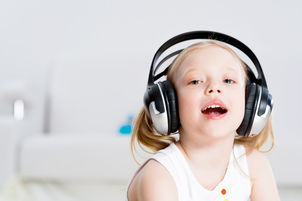 Pretty girl listening to music on headphones - Фото, изображение