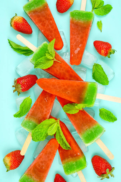 Görögdinnye ízesített nyári fagylalt popsicles a rózsaszín és kék háttér. - Fotó, kép