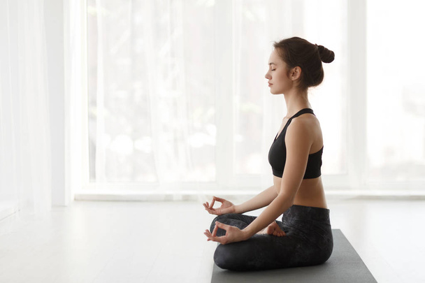 fiatal nő gyakorló jóga lótuszpóz - Fotó, kép