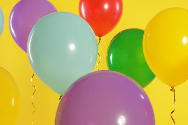 Bright balloons on color background. Celebration time - Foto, afbeelding