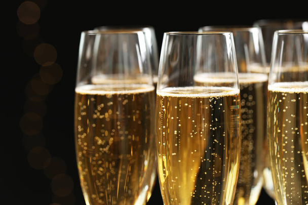 Glasses of champagne on dark background, closeup - Foto, afbeelding