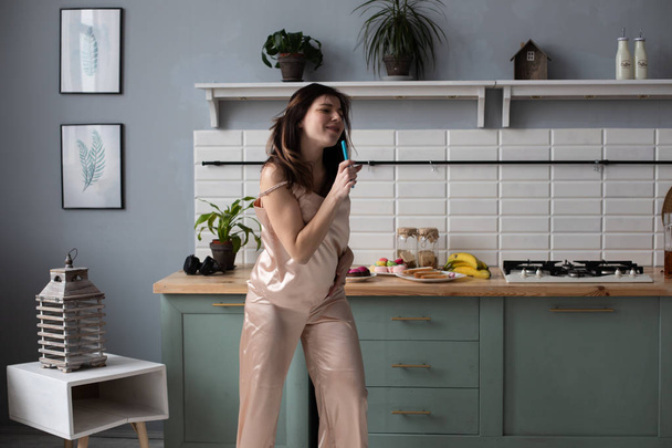 Jeune fille en pyjama dansant le matin à la cuisine
 - Photo, image