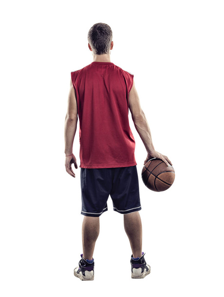 Basketbolcu elinde topu beyaz arka planda izole ile kameraya geri duruyor - Fotoğraf, Görsel