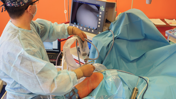 Male surgeons uses medical tools with camera while working with a patient. - Footage, Video