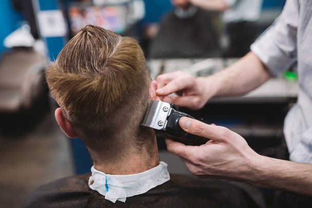 理髪店でトレンディなヘアカットを得る男のショットを閉じる。男性ヘアスタイリスト提供クライアント マシンと櫛を使用してのヘアカット - 写真・画像