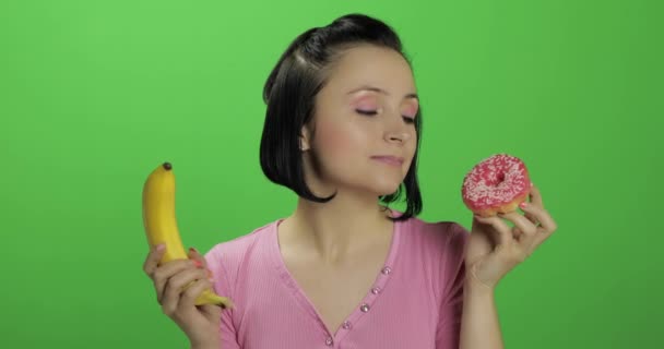 Starting healthy eating. Say no to junk food. Choice donut or banana to eat - Footage, Video