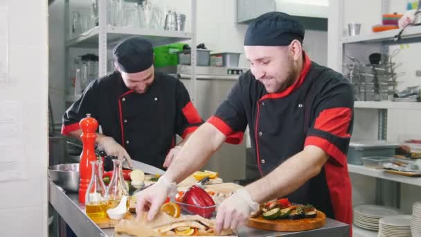 Restaurantküche zwei Männer beim Servieren von Gerichten. ein Mann, der das Fischgericht servieren will - Filmmaterial, Video