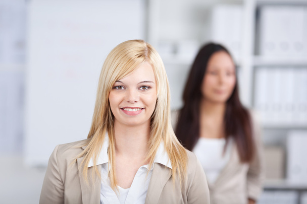 Businesswoman Smiling With Coworker In Background In Office - Foto, Bild