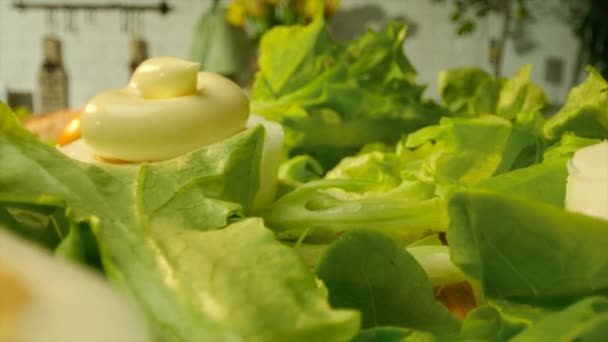 Uzavřete komerční záběr lahodných vařených vajec pokrytých majonézou s čerstvým zelení - Záběry, video