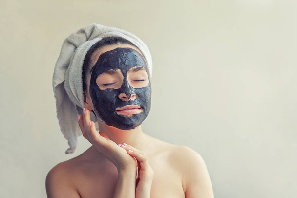 Жінка наносить чорну живильну маску на обличчя
 - Фото, зображення