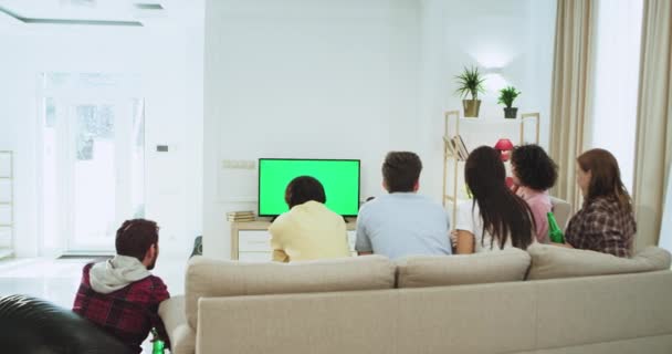 Attractive friends in a big living room watching on a green screen TV a football match they support their best football team while making a goal happy they yelling - Кадри, відео