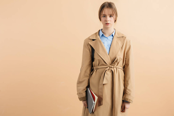 Young gorgeous lady in trench coat and blue shirt holding notepa - Foto, Imagem