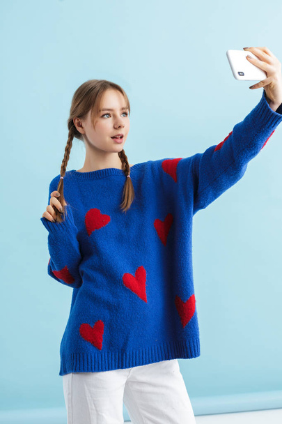 Young pretty girl with two braids in navy color oversize sweater - Фото, изображение