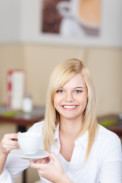 smiling woman enjoying a cup of coffee - Foto, Bild