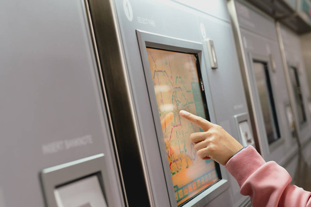 Woman choosing the destination on subway train ticket machine. Transportation concept - Photo, Image