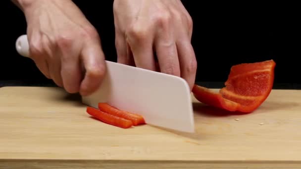Se separan los pimientos rojos grandes y se retira el núcleo. El chef sostiene un cuchillo en manos femeninas y corta una verdura sana. Cierre
 - Imágenes, Vídeo