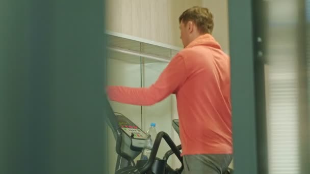 man with elliptical machine in the gym. - Felvétel, videó