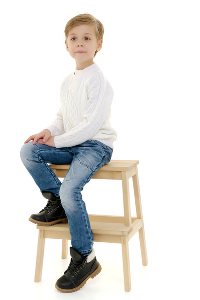 A little boy is sitting on a chair. - Φωτογραφία, εικόνα