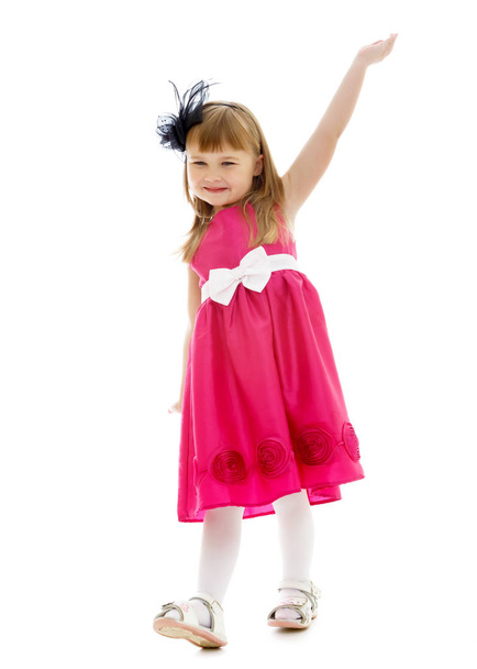 A cheerful little girl is dancing. - Фото, изображение