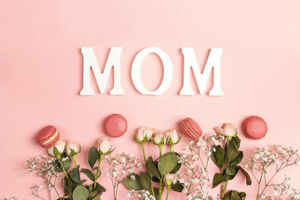 Small white flowers and roses with macarons and word Mon on pink - Photo, image