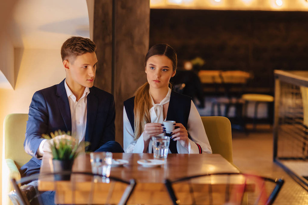 Egy elegáns pár iszik kávét a kávézóban, a fiatal üzletemberek és a szabadúszók - Fotó, kép