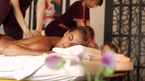 Beautiful woman getting back massage with oil in resort spa salon. Young woman receiving body massage in luxury spa center. Body relaxation and skin care. - Materiał filmowy, wideo