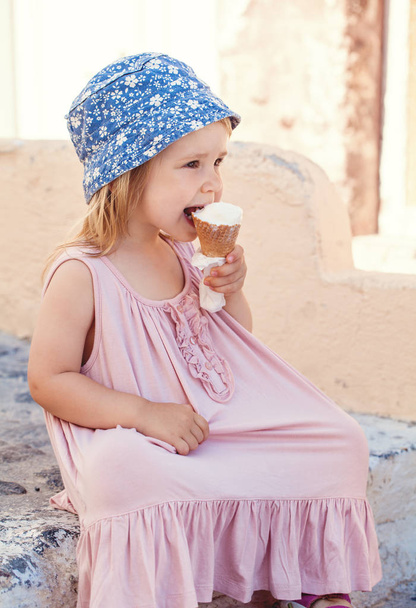 Cute little girl eating ice cream outdoors - Fotoğraf, Görsel