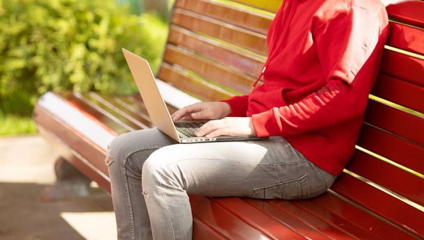 Male hands typing on laptop in the park  - 写真・画像