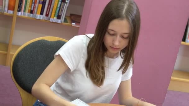 Student doet haar huiswerk in de school bibliotheek - Video