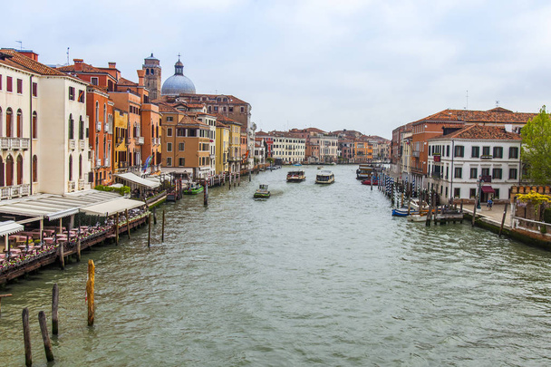 2019年4月25日、イタリア、ヴェネツィア。運河グランデの眺め。堤防の良い建築複合体によって浮かぶ様々なボート - 写真・画像
