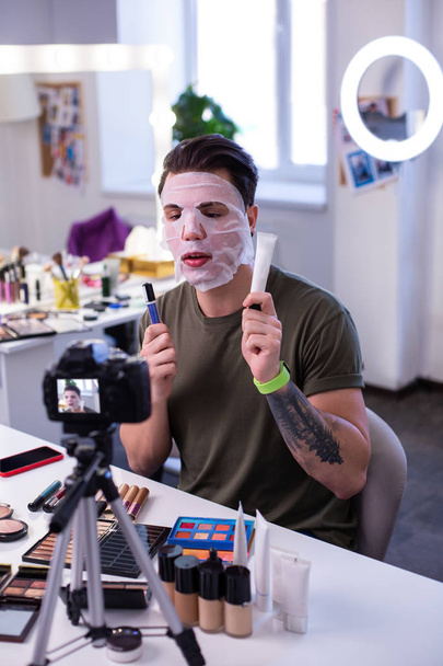 Inspired attentive man moisturizing skin with fresh mask - Foto, Imagem