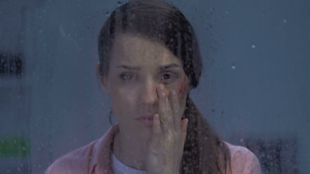Yağmurlu pencere insan hakları koruma yakınında ağlayan yaralı yanak ile Bayan, kurban - Video, Çekim