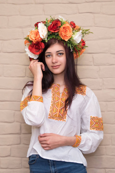 Portret dziewczyny w haftowanej koszulce i z wieniec na głowie. Wieniec to tradycyjna Ukraińska dziewczyna nakrycia głowy. Wyszywana koszula-tradycyjne ukraińskie ubrania. - Zdjęcie, obraz
