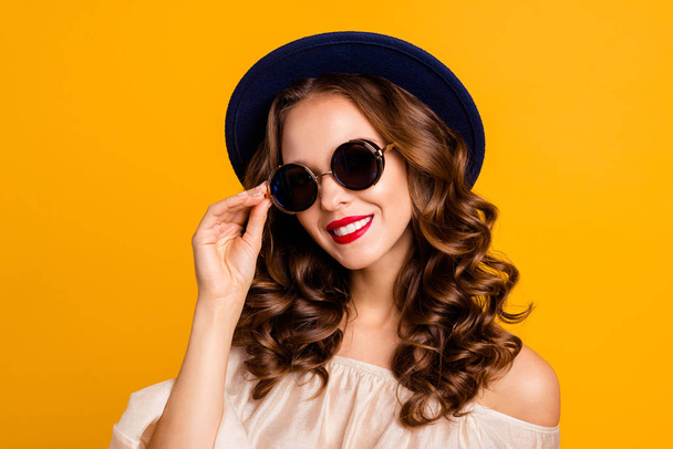 Close-up portrait of her she nice attractive fascinating lovely gorgeous cheerful cheery dreamy rich wealthy wavy-haired lady touching round glasses isolated over bright vivid shine yellow background - Foto, immagini