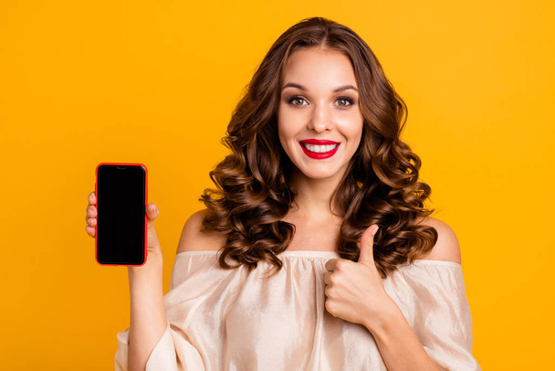 Close-up portrait of nice attractive lovely cheerful cheery wavy-haired lady using new cool 5g app internet online showing thumbup advice ad isolated over bright vivid shine yellow background - Zdjęcie, obraz