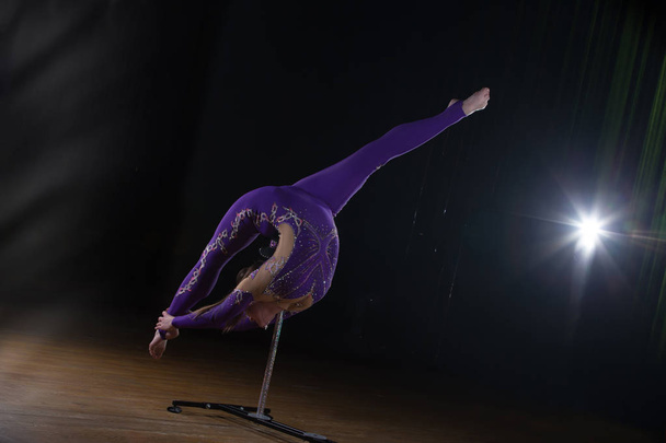 Circus színésznő elvégzi a számot egy gyönyörű füstöt. Kézi egyensúly a vesszők. Rugalmas lány test. Teljesítménye egy légi tornász egy cirkuszi - Fotó, kép