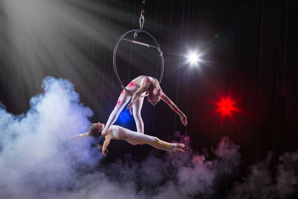 Cirkuszi színésznő Acrobat teljesítményét. Két lány elvégzi akrobatikus elemek a levegőben gyűrű. - Fotó, kép