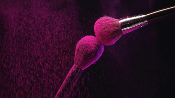 Замедленная съемка двух косметических кистей, касающихся и делающих брызги розовой краски Холи
 - Кадры, видео