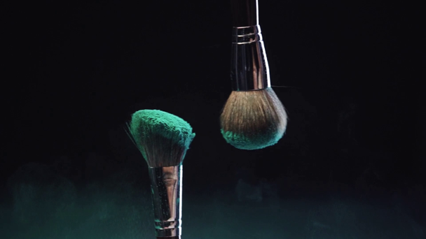 rodaje en cámara lenta de pinceles cosméticos tocando y haciendo salpicaduras de pintura verde holi
  - Metraje, vídeo