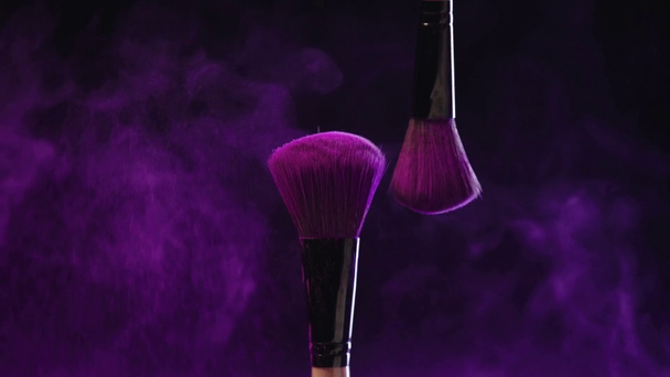 pousse au ralenti de deux pinceaux cosmétiques frottant et dispersant la peinture holi violet vif
 - Séquence, vidéo