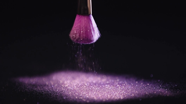Slow Motion shoot van cosmetische borstel schudden en verstrooiing glanzende paarse sparkles - Video